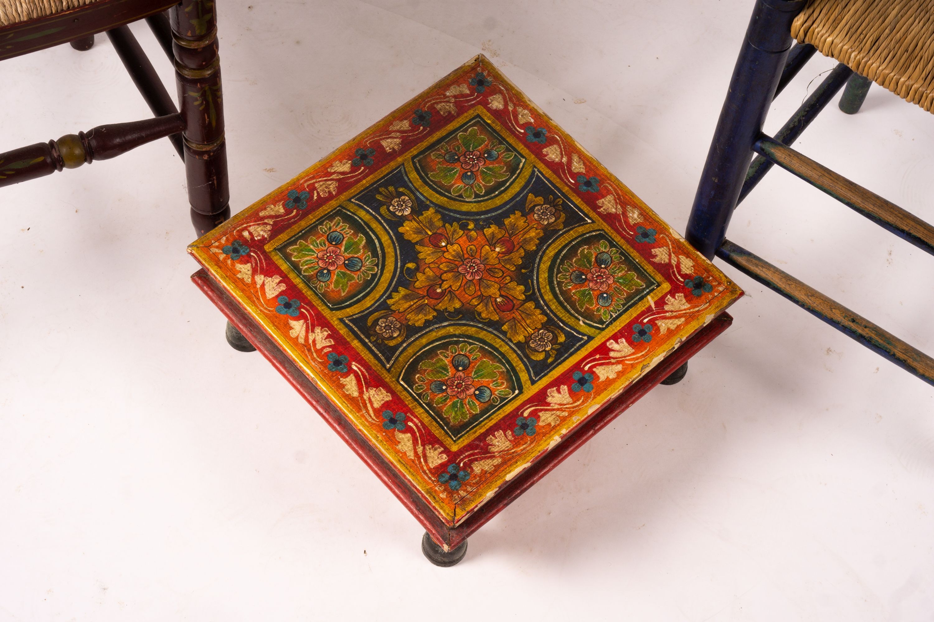 Two 19th / early 20th century Swiss painted rush seat chairs, together with a square low table